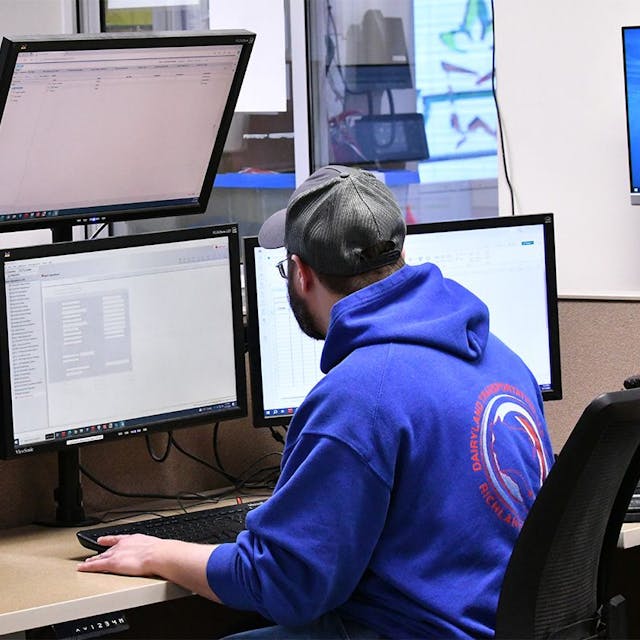 Man looking at multiple computer screens.